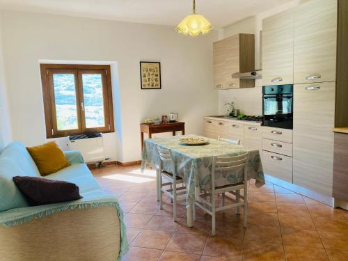 a kitchen with a table and a blue couch at Casa nella natura a Bobbio in Bobbio