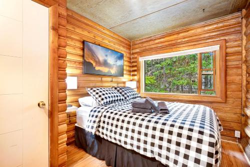 a bedroom with a bed in a room with a window at Elkhorn Lodge Vacation Rentals in Banff