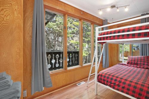 a bedroom with a bunk bed and a window at Elkhorn Lodge Vacation Rentals in Banff