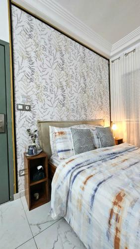 a bedroom with a large bed and a wall at Résidences C-Irène Angré in Abidjan