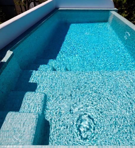 a blue swimming pool with blue water in it at Secret Spot Luxury Villa in Fira