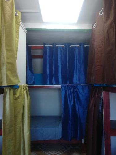 a room with blue and yellow curtains in a room at Hotel Palmar Surf Camp & School in San Carlos
