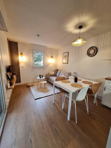 un salon avec une table et un canapé dans l'établissement Appartement cosy refait à neuf, linge fourni, à Carcans
