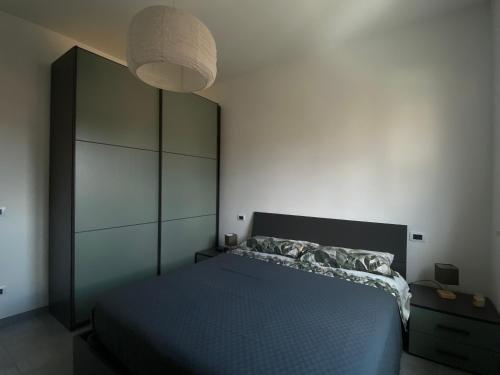 a bedroom with a blue bed and a lamp at Casa Elefantino in Acilia