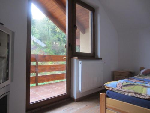 a bedroom with a sliding glass door to a balcony at Penzión Drieňovkou in Považská Bystrica