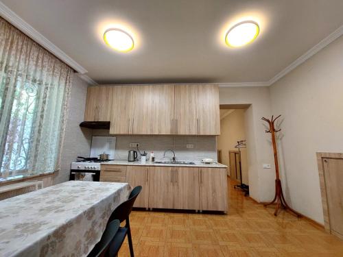 a kitchen with wooden cabinets and a table with chairs at Geo Kutaisi in Kutaisi