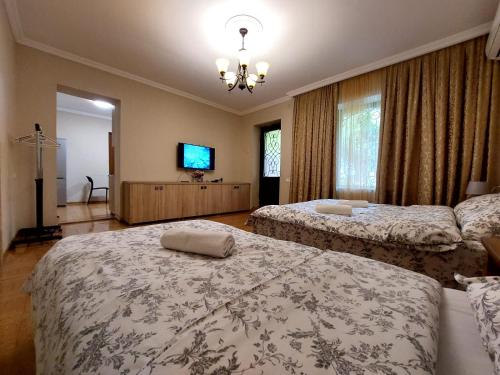 a bedroom with two beds and a flat screen tv at Geo Kutaisi in Kutaisi