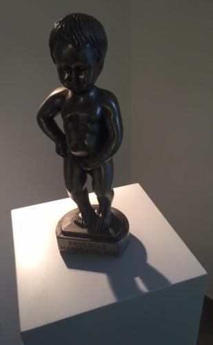 a statue of a little boy sitting on a stand at Waldhotel Brand's Busch in Bielefeld