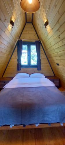 a large bed in a wooden room with a window at AĞARAN WOODEN HOUSES in Cayeli