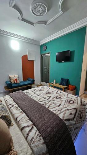 a bedroom with a large bed and a green wall at Résidences C-Irène Angré in Abidjan