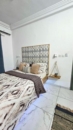 a bedroom with a king sized bed with a headboard at Résidences C-Irène Angré in Abidjan