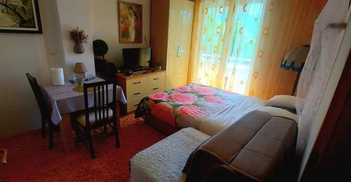 a bedroom with a bed and a desk and a table at Apartmani GS ***** Zavidovici in Zavidovići