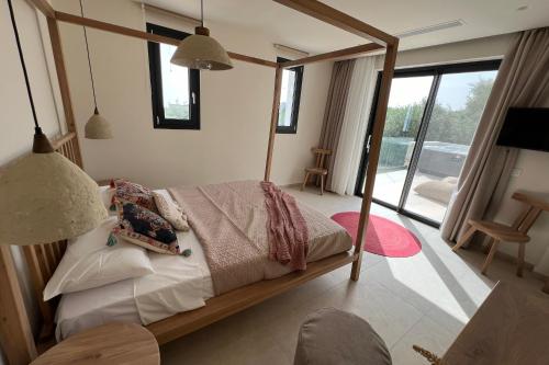 1 dormitorio con 1 cama con marco de madera en Queen of Zakynthos Luxury Villas en Amoudi