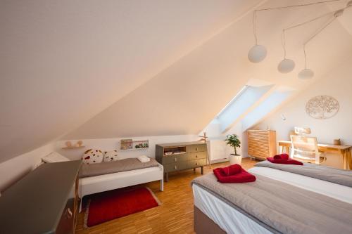 een slaapkamer op zolder met 2 bedden en een bureau bij TAMLiving Graz Center 2 Schlafzimmer Comfort Air conditioning WIFI XBOX in Graz