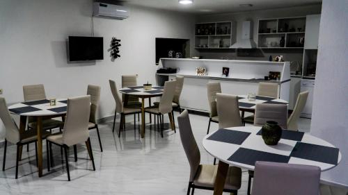 a dining room with tables and chairs and a kitchen at New House Kobuleti in Kobuleti