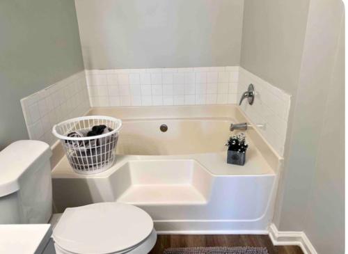 a bathroom with a toilet and a tub with a basket at King Suite - Private Bath - Hot Tub Room 1 in Atlanta