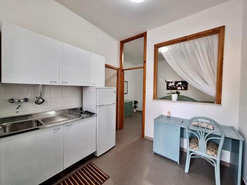 eine Küche mit weißen Schränken und einem blauen Tisch in der Unterkunft Villa Amica in Vieste