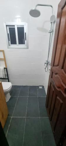 a bathroom with a shower and a toilet and a mirror at Résidences C-Irène Angré in Abidjan