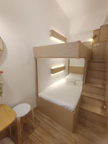 VG Pension & Residences في Adlawon: غرفة صغيرة مع سرير بطابقين وطاولة