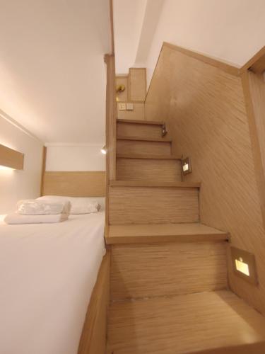een trap naar een slaapkamer met een bed bij VG Pension & Residences in Adlawon