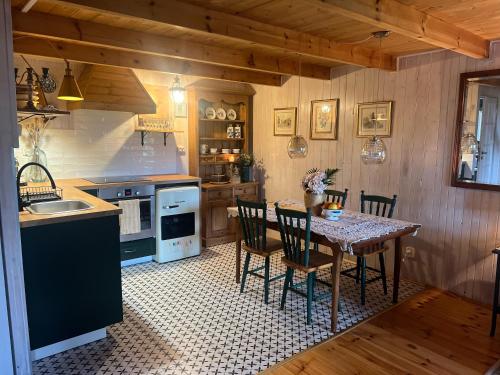 a kitchen with a table with chairs and a sink at Kaszubski sen in Smołdzino