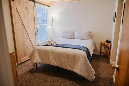 a bedroom with a bed with a window and a bedskirtspectspectspectspects at NEW! Townhouse - Tenney Mountain Resort in Plymouth
