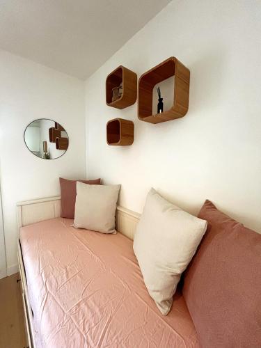 une chambre avec un lit avec deux oreillers et un miroir dans l'établissement Le nid douillet de Jade, à La Londe-les-Maures