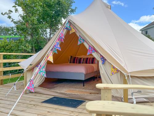 a tent with a bed in it on a deck at Greystones Glamping - Tent 1 in Greystones