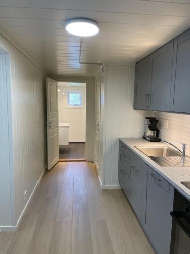 a kitchen with white cabinets and a wooden floor at Aurland Feriehus in Aurland