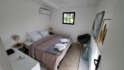 - une petite chambre avec un lit et une table dans l'établissement Le Ptit Gibs, à Petit-Bourg