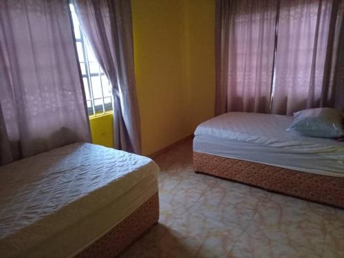 a bedroom with two beds and a window at Abokobi Cosy Home in Accra