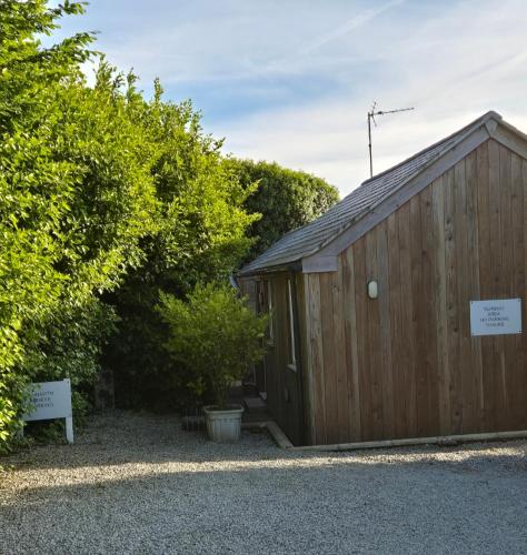 a wooden shed with a sign in front of it at Lanarth Chalet in Hayle Cornwall in Hayle