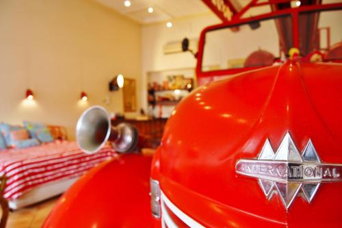 a red car parked in a bedroom with a bed at Fire Station Inn in Adelaide