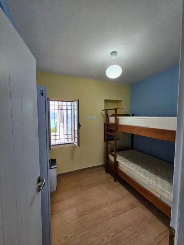 a room with a bunk bed and a window at Villa Dario in Vlorë