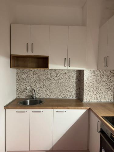 - une cuisine avec des placards blancs et un évier dans l'établissement M&D Apartment, à Struga