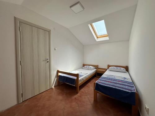 een kleine kamer met 2 bedden en een raam bij Jovana Apartments in Budva