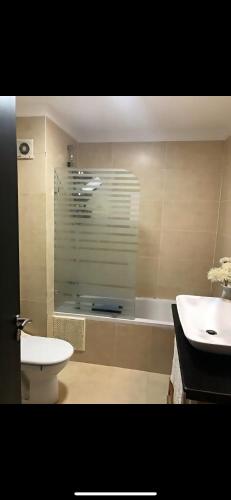 a bathroom with a toilet and a sink and a tub at villa amplia y acogedora-alcudia smir in Fnidek