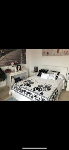 a bedroom with a bed with a black and white comforter at villa amplia y acogedora-alcudia smir in Fnidek