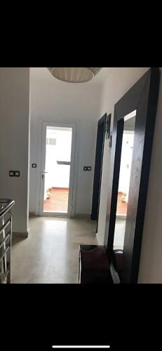 a room with a hallway with two mirrors and a door at villa amplia y acogedora-alcudia smir in Fnidek