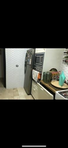 a kitchen with a refrigerator and a stove top oven at villa amplia y acogedora-alcudia smir in Fnidek