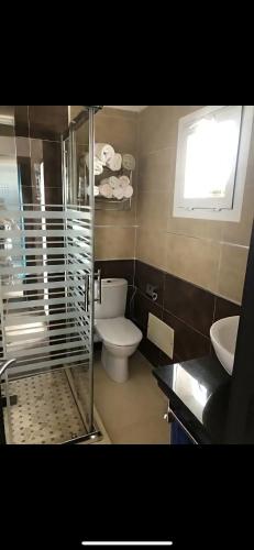 a bathroom with a toilet and a glass shower at villa amplia y acogedora-alcudia smir in Fnidek
