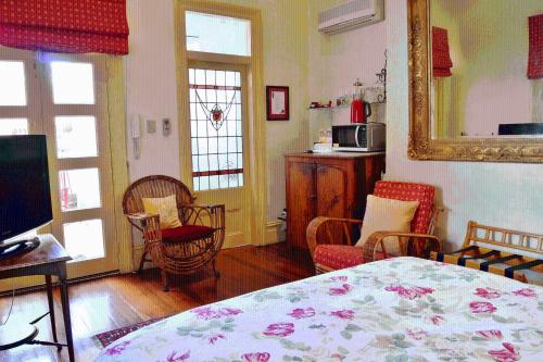 a room with a bed and chairs and a television at Fire Station Inn in Adelaide