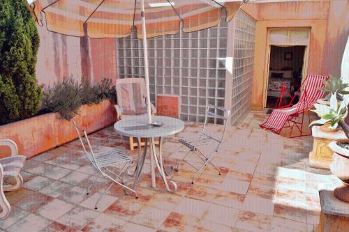 a patio with a table and chairs and an umbrella at Fire Station Inn in Adelaide