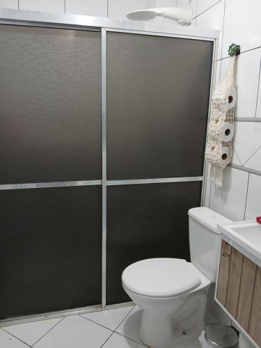 a bathroom with a shower with a toilet and a sink at Praia Guilhermina Sol Mar in Praia Grande