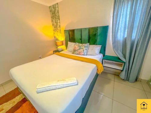 Un pequeño dormitorio con una cama con una toalla. en GoldenWays Apartment 3 en Mbabane