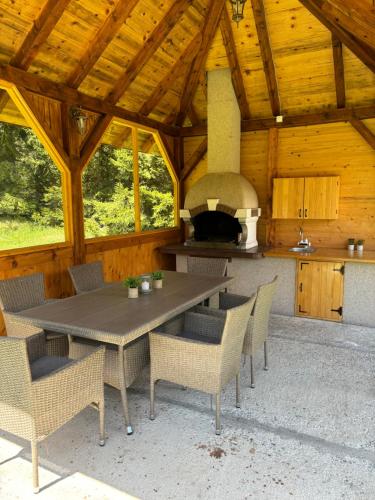 d'une terrasse avec une table, des chaises et un four. dans l'établissement Tara Cottage, à Bajina Bašta