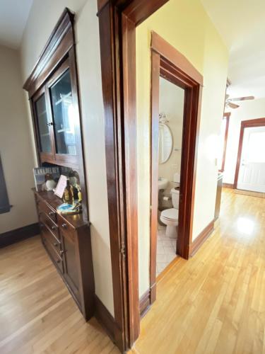 a bathroom with a toilet and a wooden floor at Irving Park updated vintage top unit 2-flat in Chicago