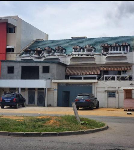 a large building with cars parked in front of it at Résidences C-Irène Angré in Abidjan