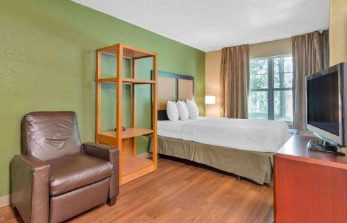 オーランドにあるExtended Stay America Suites - Orlando - Maitland - Summit Tower Blvdのベッドと椅子付きのホテルルーム