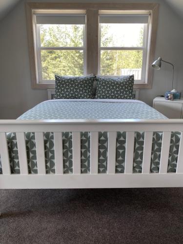 een wit bed in een slaapkamer met een raam bij Fieldstone Guesthouse in Clearwater